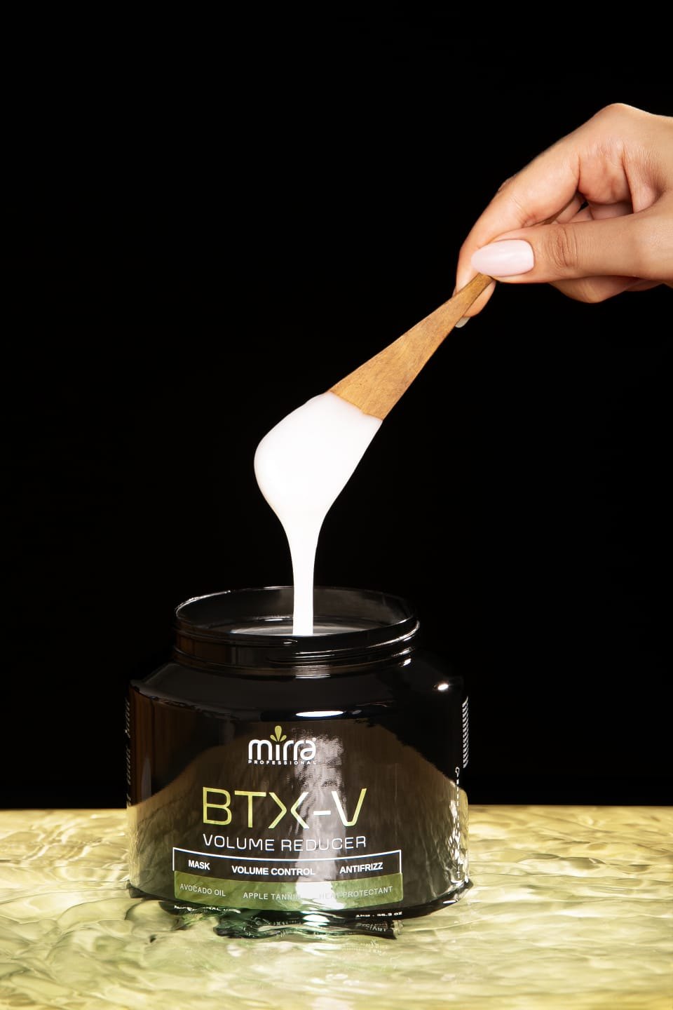 Pote preto do BTX-V Volume Reducer da Mirra Professional com espátula de madeira levantando a máscara branca