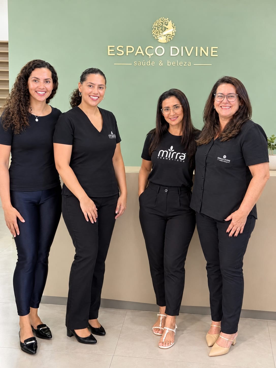 Equipe do Espaço Divine reunida diante da logo do salão